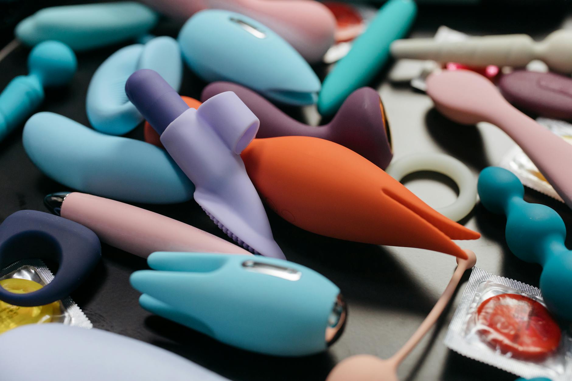 Close-up of hands holding a sleek blue lemon vibrator against a purple background